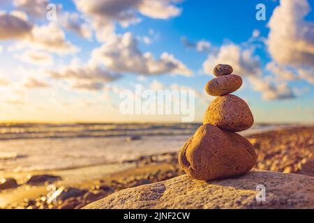Stone tower on the beach with evening sunset light Stock Photo