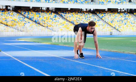 bearded man in sportswear standing at starting pose before running at stadium,stock image Stock Photo