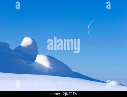 Snowy winter arctic landscape, crescent moon in the blue sky. Stock Photo