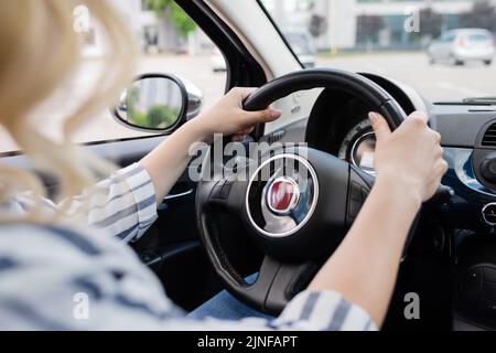 Cropped view of blonde driver holding steering wheel of car,stock image Stock Photo