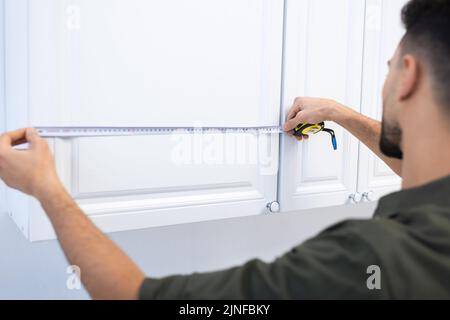 Blurred muslim man measuring kitchen cabinet at home,stock image Stock Photo