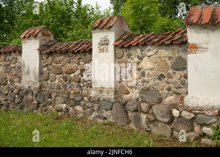 Old stone fence in the park of ancient castle of Kraslava Stock Photo