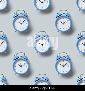 Seamless pattern of old-fashioned blue alarm clocks on blue background. Flat lay. Stock Photo