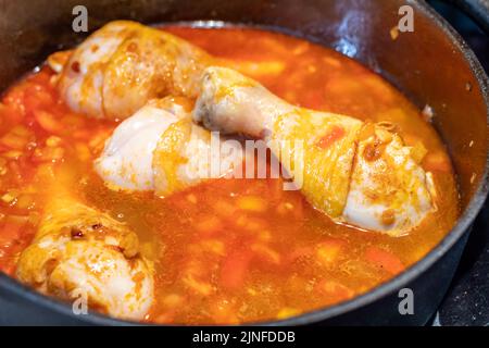 Chicken legs with roasted onion in the iron pan. Dinner or lunch cooking, detail view. Stock Photo