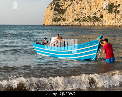 Blue tour boat floating on the Mediterranean sea next to fnideq City Stock Photo