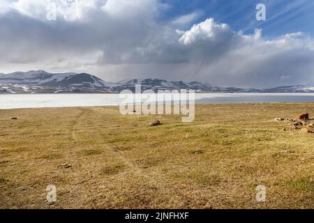 Beautiful and frozen lake Paravani and snowy mountains in the ...