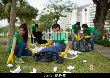 Young people picking up garbage in local park Stock Photo