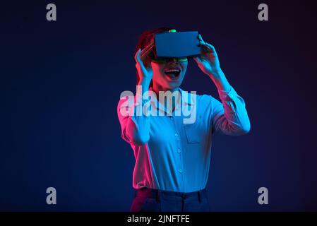 Cheerful Vietnamese young woman using VR glasses Stock Photo