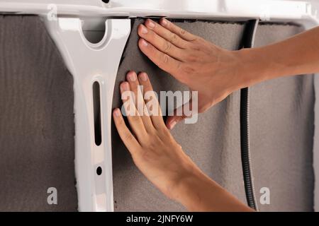 Close up view of unrecognizable young man hands placing and installing the isolation of a camper van convertion order Stock Photo