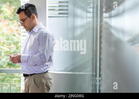 Mature businessman reading message in his smartphone Stock Photo
