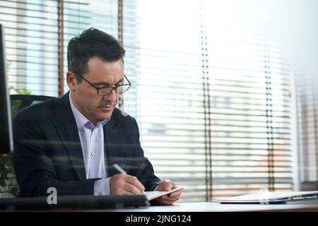 Businessman writing plans and ideas in his diary Stock Photo