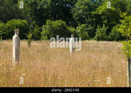 Regiment of Trees, stone soldiers carved by Patrick Walls stand in a grid, Langley Vale Centenary Wood, Epsom, Surrey, England, UK, July 2022 Stock Photo