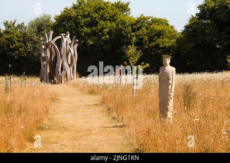 Regiment of Trees, stone soldiers carved by Patrick Walls stand in a grid, Langley Vale Centenary Wood, Epsom, Surrey, England, UK, July 2022 Stock Photo