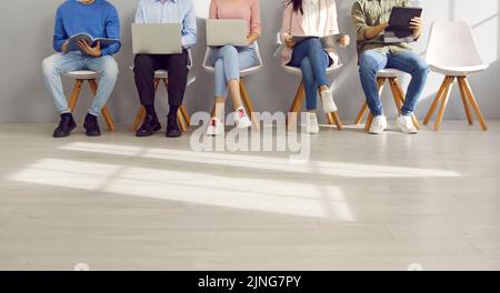 Cropped shot of business people using laptop and tablet computers while waiting in line Stock Photo