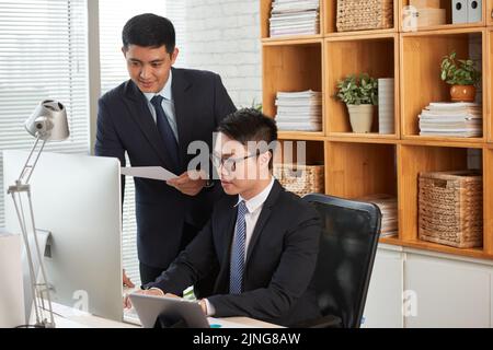 Team of businessmen working on project together Stock Photo