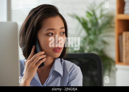 Attractive female entrepreneur calling on the phone Stock Photo