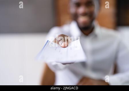 African Business Man Giving Paycheck Or Payroll Cheque Stock Photo