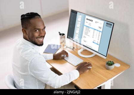 Businessperson Working On Computer With Invoice On Computer Screen In Office Stock Photo