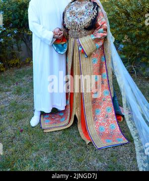 Moroccan Wedding. A Groom Wearing A Djellaba Holds His Bride Who Is ...