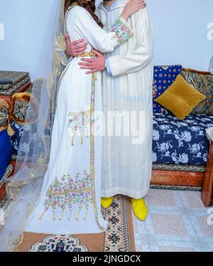 Moroccan Wedding. A Groom Wearing A Djellaba Holds His Bride Who Is ...