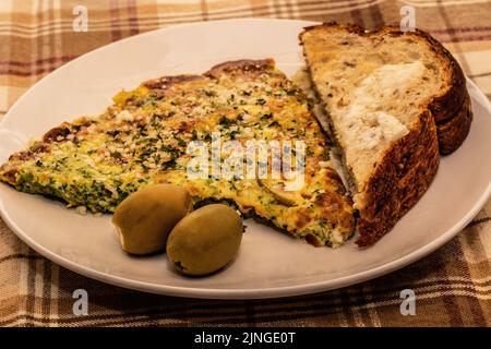 Mediterranean Broccoli and Cheese Omelet with Feta Cheese Stuffed Green Olives and Siebenfelder Bread toasted. Stock Photo