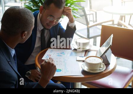Pensive coworkers analyzing information in financial report Stock Photo