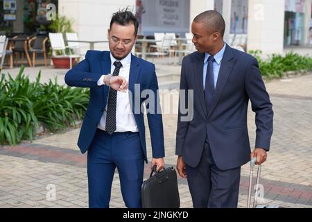 Business people checking time when hurrying to airport Stock Photo