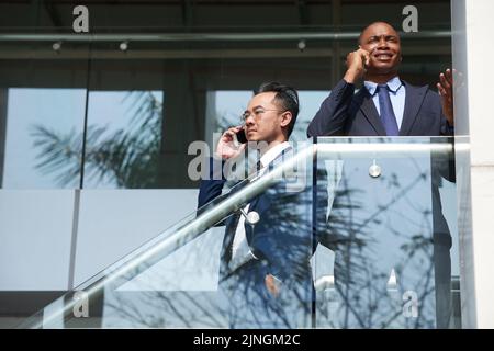 Business people standing on stairs and calling on the phone Stock Photo