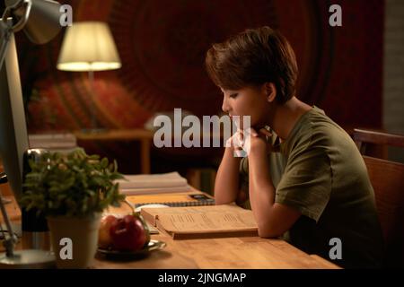 Asian young woman reading students book at her table at home Stock Photo