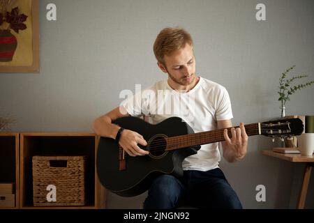 Handsome young man practicing guitar play at home Stock Photo