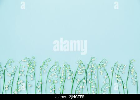 Lilies of the valley on a blue background. Greeting card, copy space Stock Photo