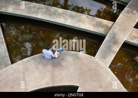 High angle view of romantic young couple relaxing near fountain Stock Photo