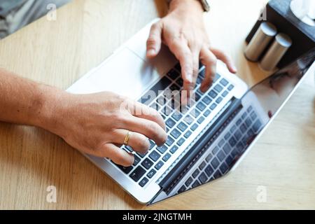Photo top view of hands of business man typing on keyboard of laptop computer, free copy space. Implementation of modern technologies into lifestyle Stock Photo