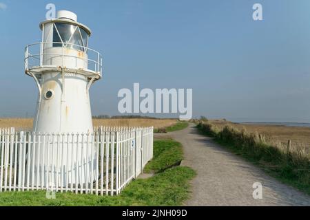 East Usk lighthouse with extensive reedbeds and the Severn Estuary in the background, RSPB Newport Wetlands Nature Reserve, Gwent, Wales, UK, March Stock Photo