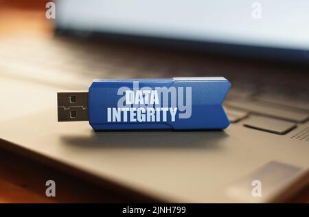Computer and security concept. On the laptop keyboard is a flash drive with the inscription - Data integrity Stock Photo