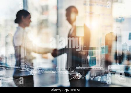 Determined to achieve success. Defocused shot of two businesspeople shaking hands in an office. Stock Photo