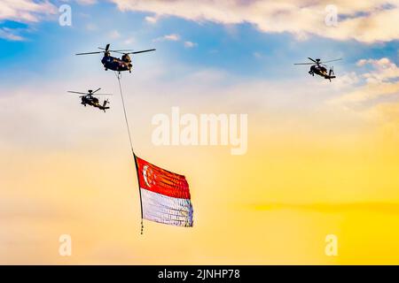 Chinook helicopter flying a giant Singapore national flag during National Day Parade. Stock Photo