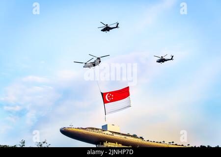 Chinook helicopter flying a giant Singapore national flag during National Day Parade. Stock Photo