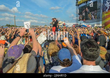 Bruce Springsteen engages with young male fan amidst the crowd at the New Orleans Jazz and Heritage Festival on April 29, 2012 Stock Photo