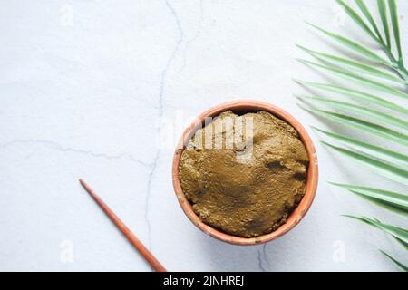 The wooden bowl with rehydrated henna on table Stock Photo