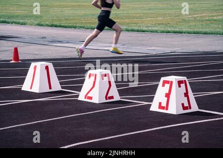 running tracks at the stadium. the start line on the track against the background of a running girl blurred in motion. athletics stadium Stock Photo