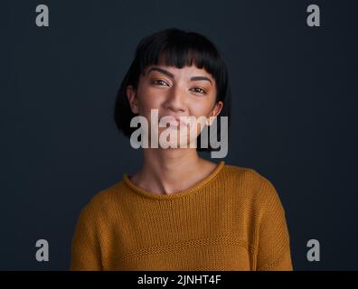 Aww, pretty please. Studio shot of an attractive young woman pouting against a dark background. Stock Photo