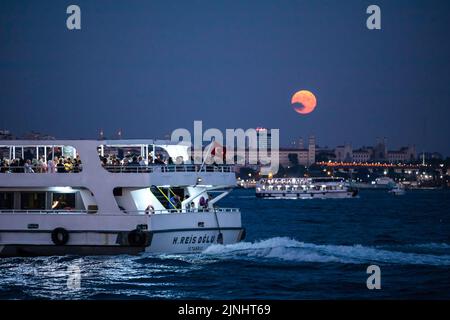 Istanbul, Turkey. 11th Aug, 2022. With the full moon appearing in the sky, a boat seen sailing at the Bosphorus. Boats passing through the Bosphorus and city line ferries were seen in Istanbul with the full moon appearing during the sky in the evening hours. Credit: SOPA Images Limited/Ģ����ý Live News Stock Photo