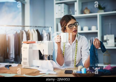 This works for me. an attractive young fashion designer enjoying a coffee while working in her design studio. Stock Photo