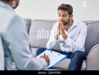I have a lot of thinking to do. an stressed out young man having a discussion with his doctor while being seated on a sofa inside of a doctors office Stock Photo
