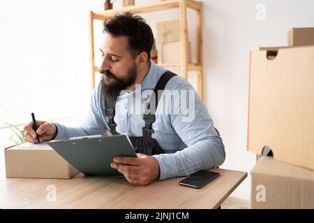 Small business, SME entrepreneur owner delivery service and packing box, business owner working checking order to confirm before sending customer in Stock Photo