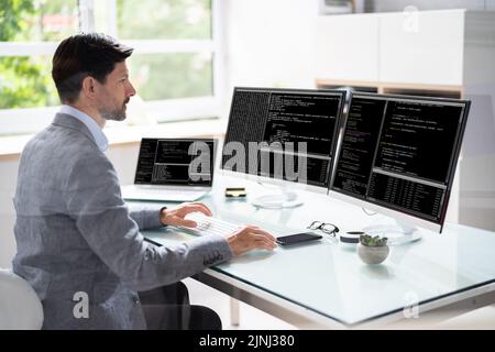 Computer Programmer Writing Program Code On Computer In Office Stock Photo