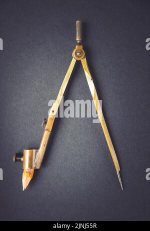 Old vintage pair of compasses on a dark background Stock Photo