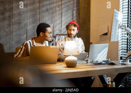 Two men working on computer at home office Stock Photo
