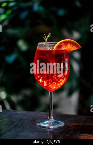 Aperol spritz cocktail garnish with grapefruit and rosemary in front of dark background. Summer refreshing italian cocktail drink in restaurant bar. Stock Photo